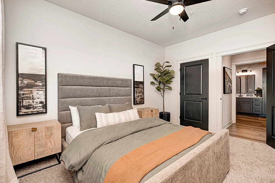 Modern apartment bedroom looking into a large bathroom