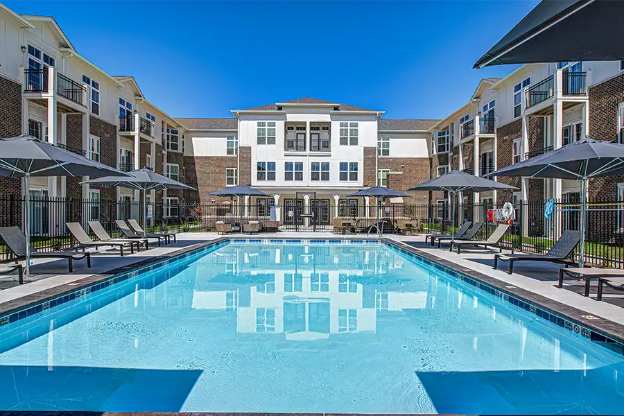 Pristine pool surrounded by apartment buildings at Penrose on Mass Apartments.